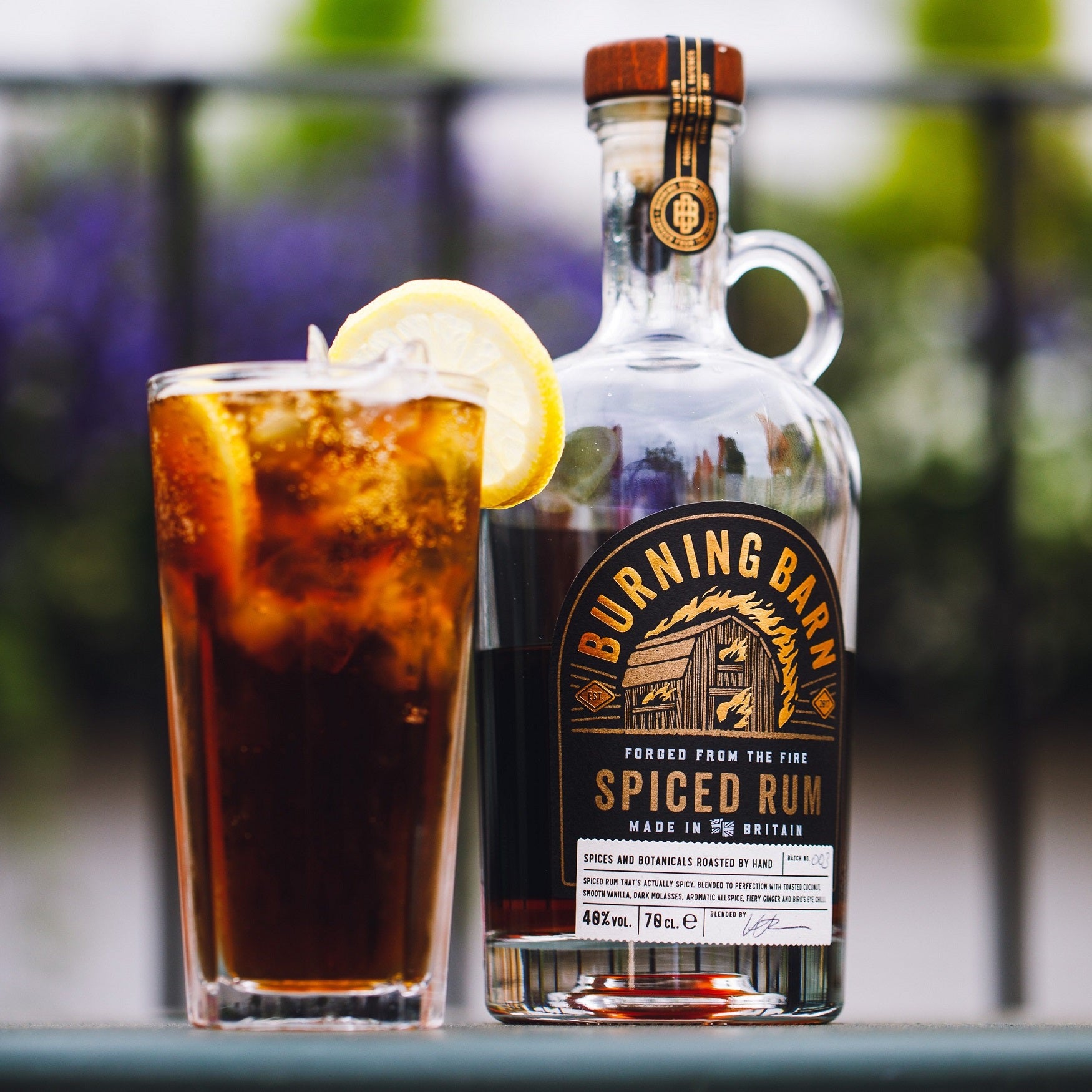 Spiced Rum cocktail with fresh lemon slice and rum bottle 