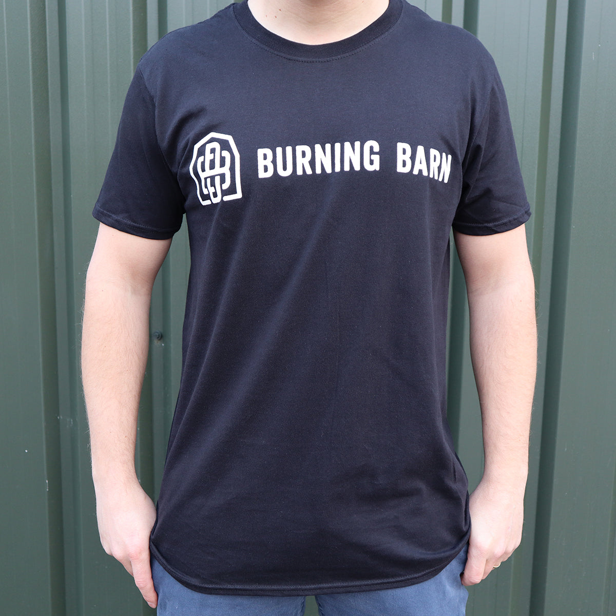 Person wearing a black t-shirt with the Burning Barn logo on it - view of the front
