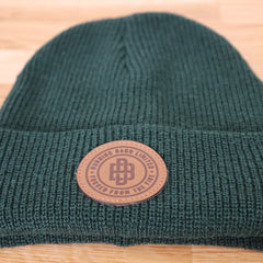 Front view of green beanie with Burning Barn logo on it