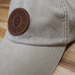 Side view of a grey cap with the Burning Barn logo on it
