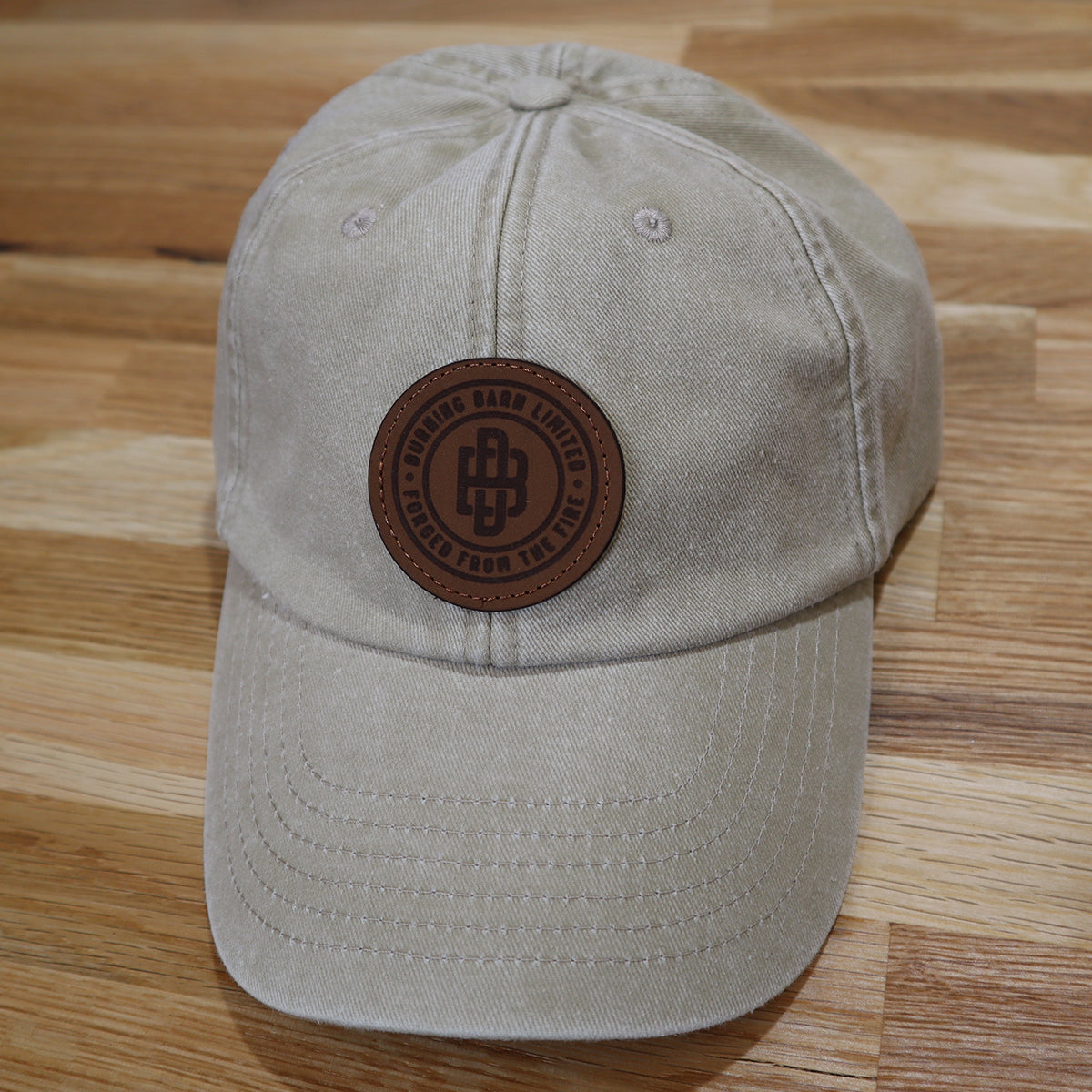 Front view of a grey cap with the Burning Barn logo on it