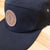 Side view of black cap with Burning Barn logo imprinted on the front