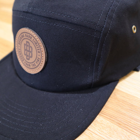 Side view of black cap with Burning Barn logo imprinted on the front