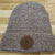 Front view of oatmeal coloured beanie with Burning Barn logo on it